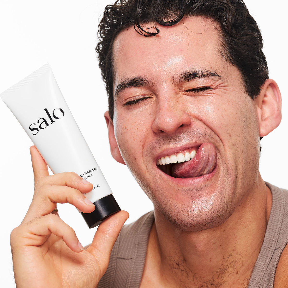 Man laughing while holding the Salo Remineralizing Cleanser