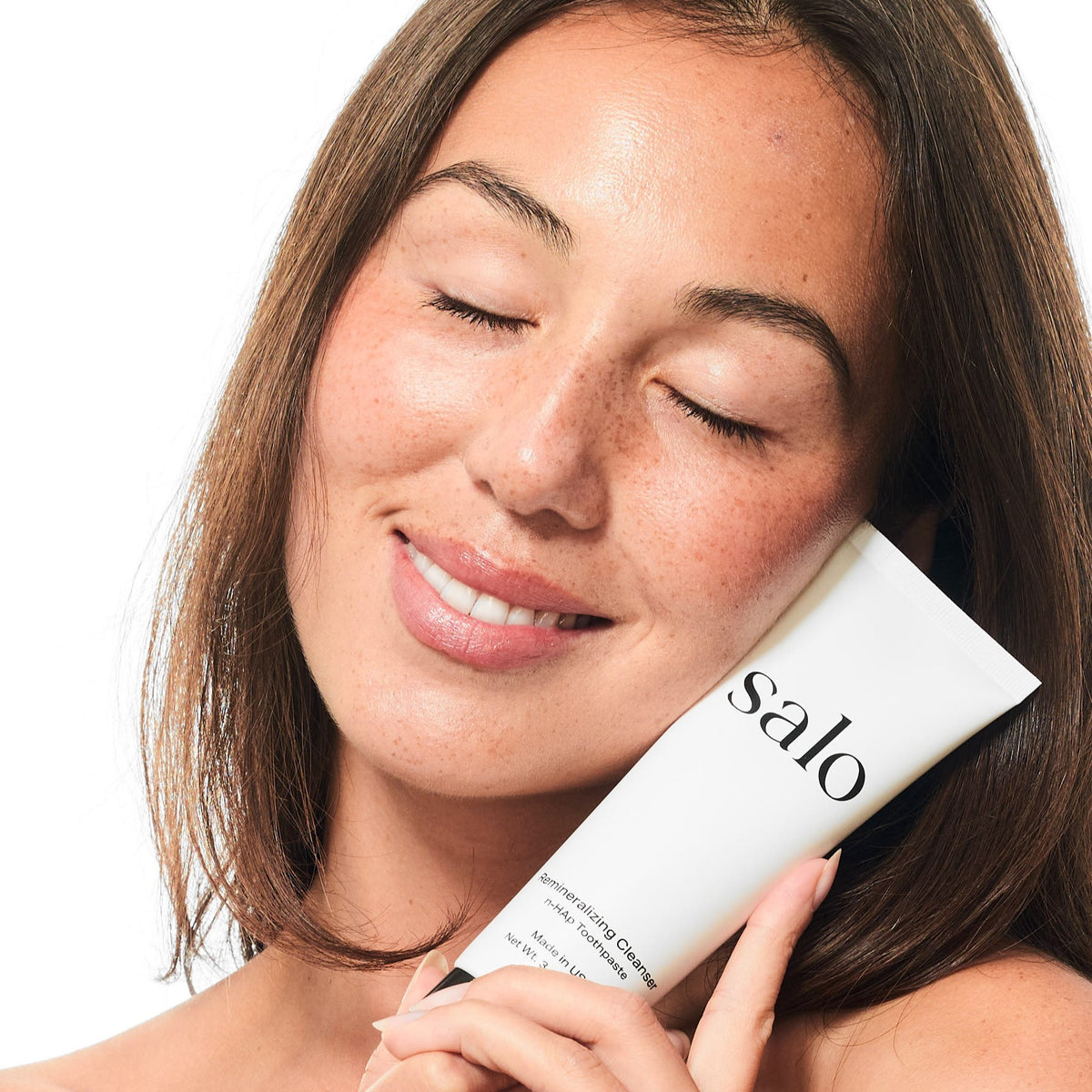 Woman holding the Salo Remineralizing Cleanser tube