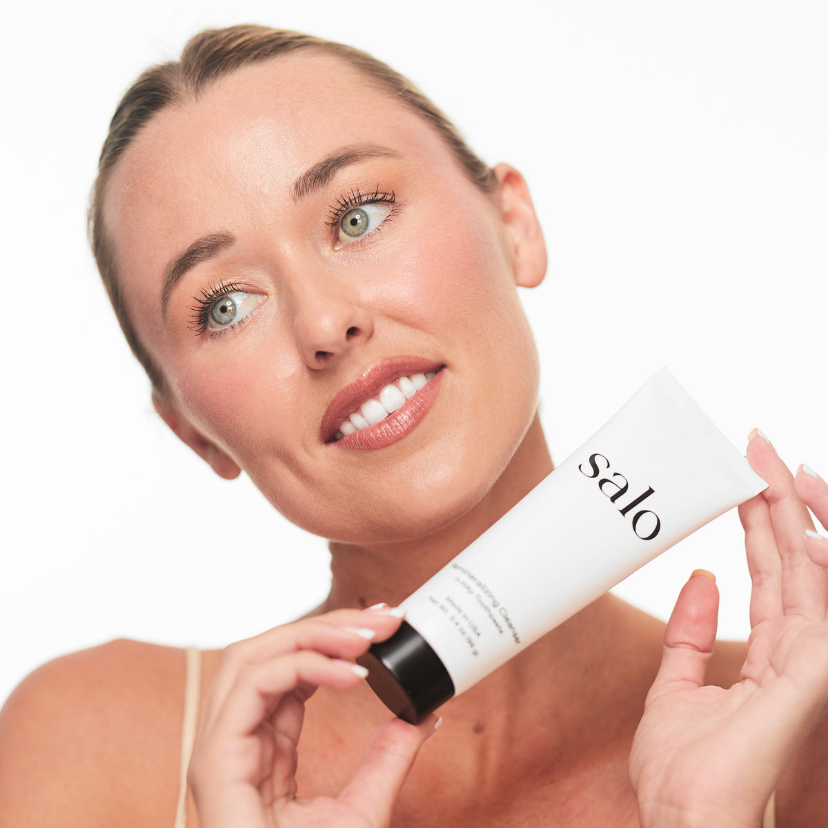 Woman holding the Salo Remineralizing Cleanser tube